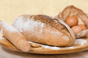 Homemade bread on a wooden board, on rural vintage table.