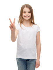 little girl in white t-shirt showing peace gesture