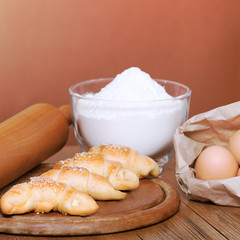 Bakery products and baking ingredients on a wooden table.