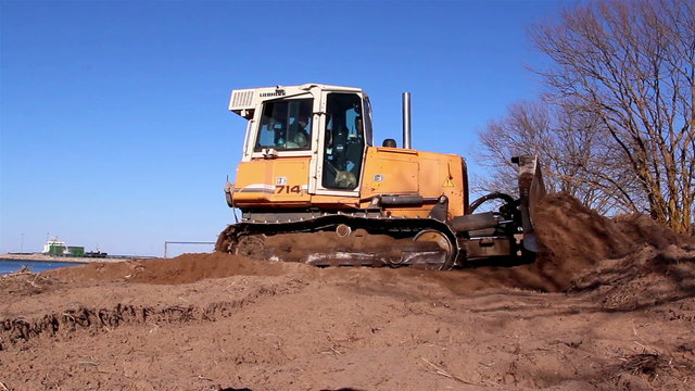 A yellow bulldozer grabbing some soil