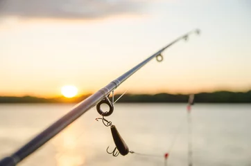Wall murals Fishing fishing on a lake before sunset