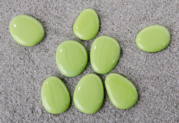 Composition of green pebbles on the sand