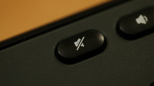 Finger pressing button with no sound symbol on keyboard