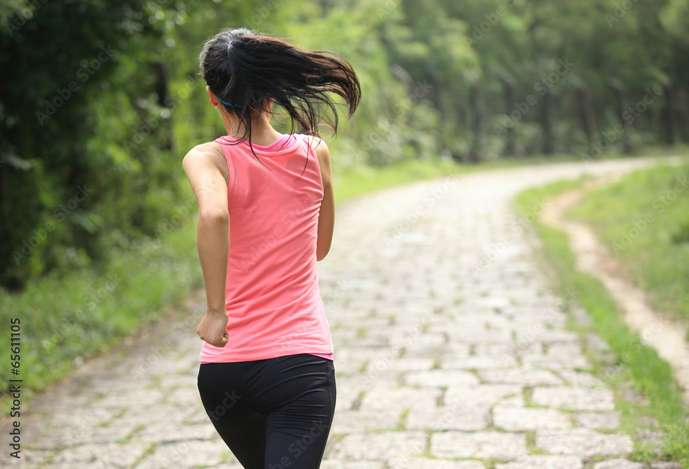 Wall mural woman runner athlete running on forest trail