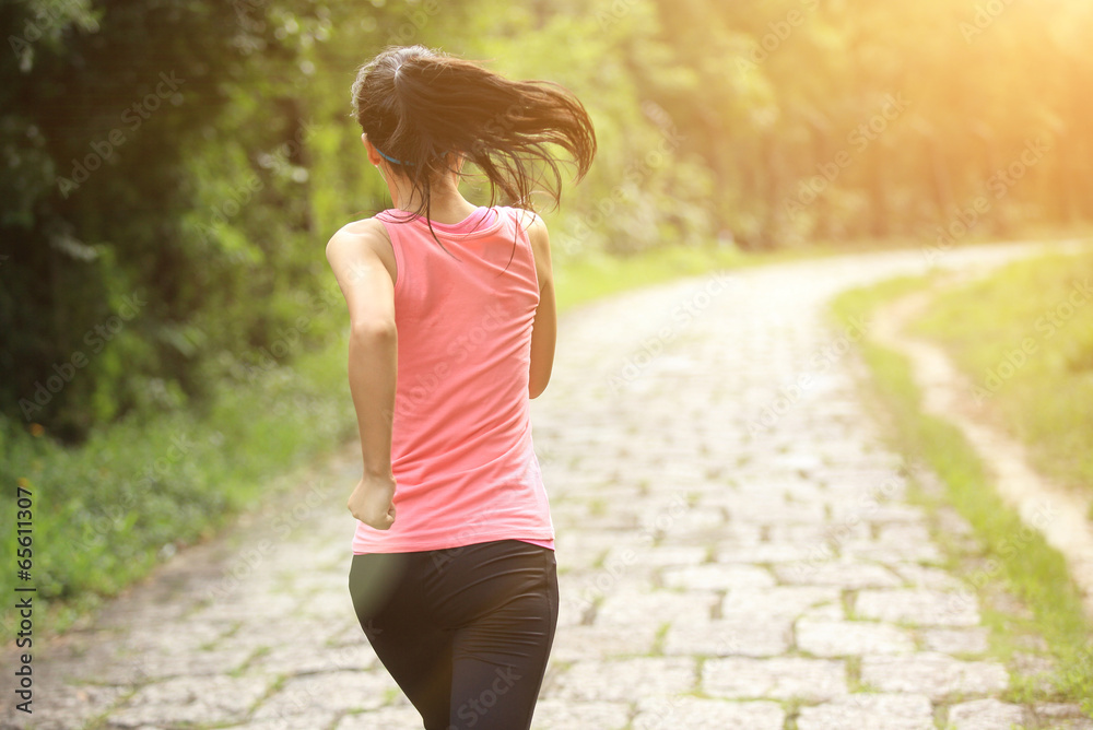 Wall mural woman runner athlete running on forest trail