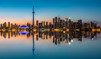 Fotobehang De skyline van Toronto in de schemering weerspiegeld in de Inner Harbor Bay © mandritoiu