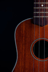 Obraz premium Ukulele hawaiian guitar over dark background.