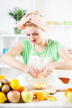 Young woman preparing fruit salad