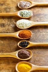 Various spices in wooden spoons.