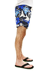 Closeup on legs of male in shorts and flip flops.
