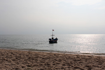 A fishing boat, sea in background and blue sky.