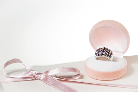 A silver ring inside ring box with white card.