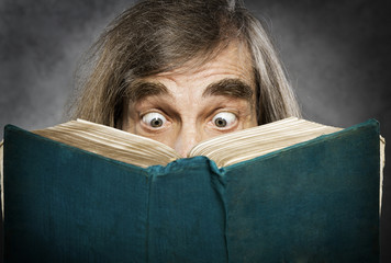 Senior reading open book, suprised old man,  amazing eyes