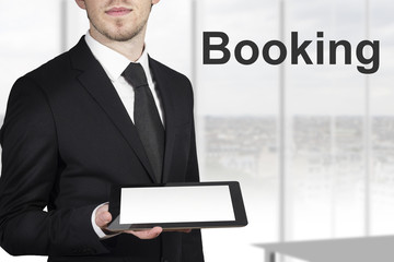 businessman holding tablet booking
