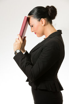 Black hair business dressed woman holding red book