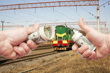  Hands with notes of dollars against the train on the railroad