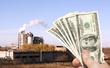 Hands with US  notes against plant