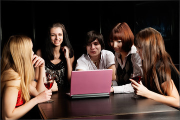 Group of young people with laptop in cafe