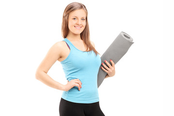 Naklejka premium Attractive woman holding an exercise mat