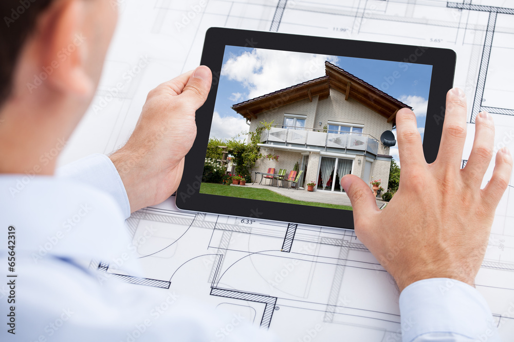 Poster architect analyzing house on digital tablet over blueprint
