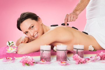 Obraz na płótnie Canvas Woman Receiving Hot Stone Therapy In Spa