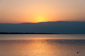 Fototapeta na wymiar Sunrise over Jordan mountain Dead Sea reflection on water Israel