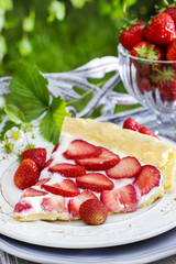 Strawberry cake on wooden tray in summer garden