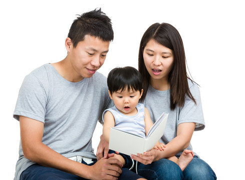 Young couple reading book with baby boy