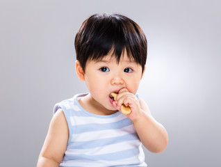 Cute little boy eating cookie