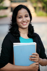 Happy young female student at college campus