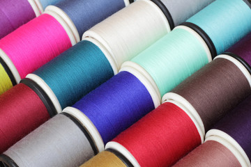 Spools of thread  multicolored background closeup