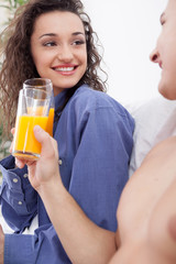 young couple having breakfast in bed together