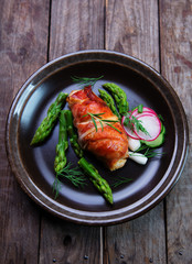 chicken breast wrapped in prosciutto ham with green asparagus