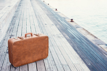 brown vintage suitcase and dock background