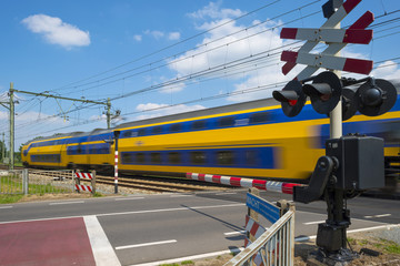 Train riding over a rail crossing in spring