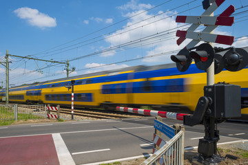 Train riding over a rail crossing in spring