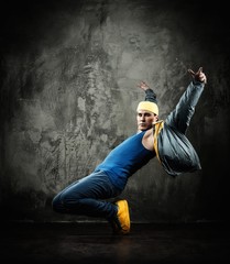Plakat Man dancer in cap and jacket showing break-dancing moves