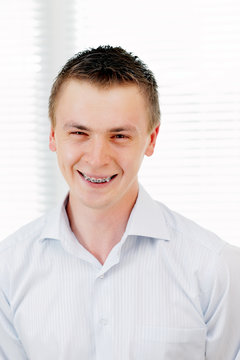 Smiling young man with orthodontic braces.
