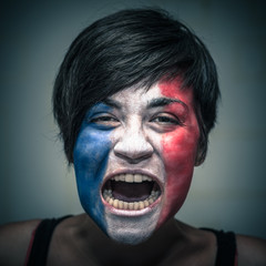 Angry woman with flag of France painted on face