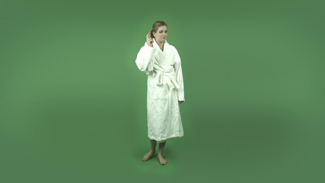 attractive caucasian girl in bathrobe isolated on green with
