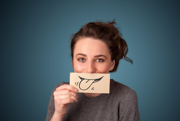 Pretty young girl holding white card with smile drawing