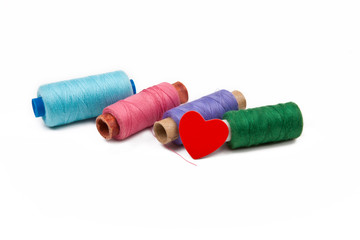 Нитки, шпульки на белом фоне
