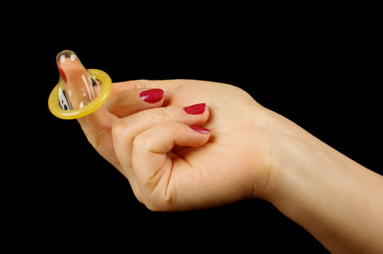 Seduction concept female hand with condom