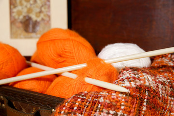 Balls of wool and needles, in wooden box.