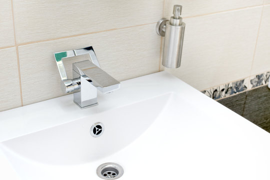 Chromium-plate tap on white sink.