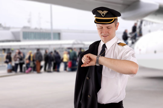 The pilot looks at his watch and waits for passengers