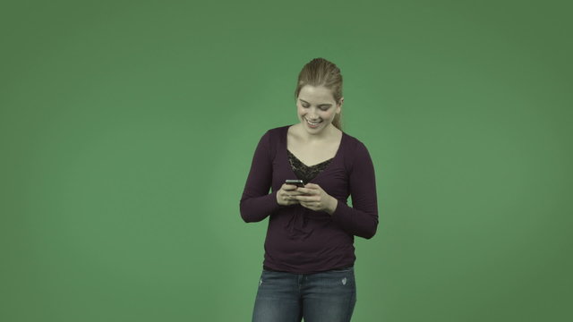 attractive casual caucasian girl isolated on green sending text