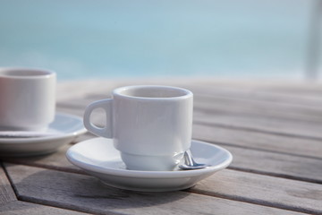 Pair of coffee cups on the table in a seaside cafe.