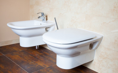 Hygiene. White porcelain bidet and toilet. Interior of bathroom.