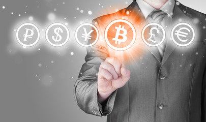 Choosing bitcoins, businessman pressing touch screen button.